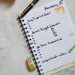 Flatlay of a planner with a pen, candle, stickers and washitape